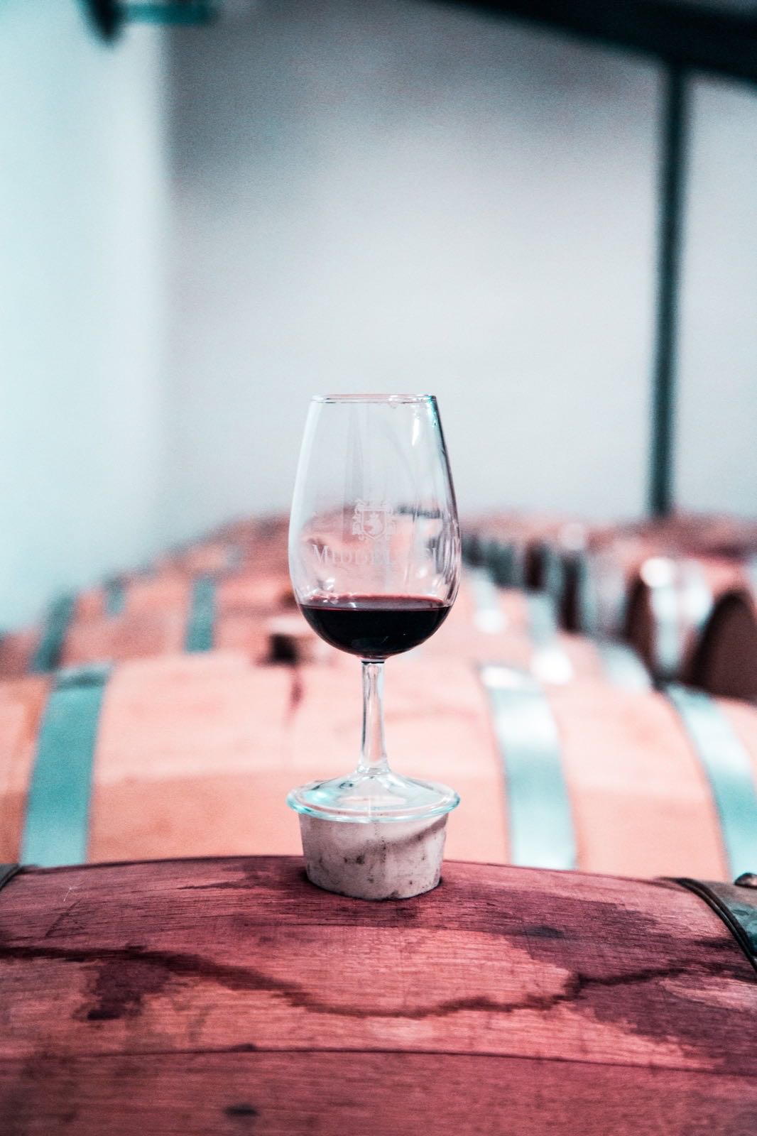 Verre de vin rouge posé sur un fût de chêne